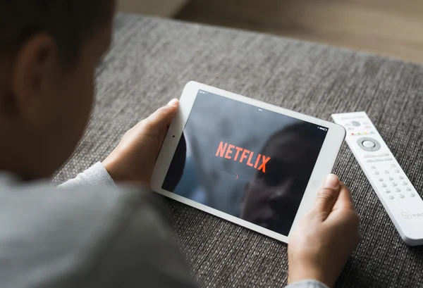 Boy using tablet pc to watch netflix online — Stock Fotó