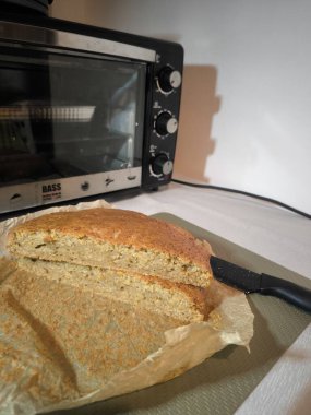 Beyaz arka planda bıçaklı ev yapımı ekmek.