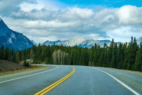 Estrada rural na floresta com montanhas ao fundo. Alberta Highway 11 (David Thompson Hwy), Jasper National Park, Canadá. — Fotografia de Stock