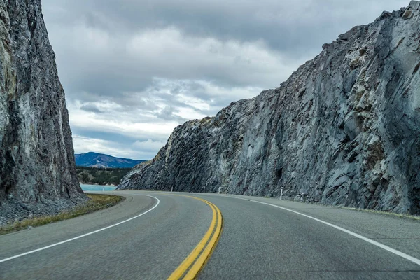 Estrada de estrada na floresta, pedras em ambos os lados com montanhas no fundo. Windy Point. Alberta Highway 11 (David Thompson Hwy), Jasper National Park, Canadá. — Fotografia de Stock