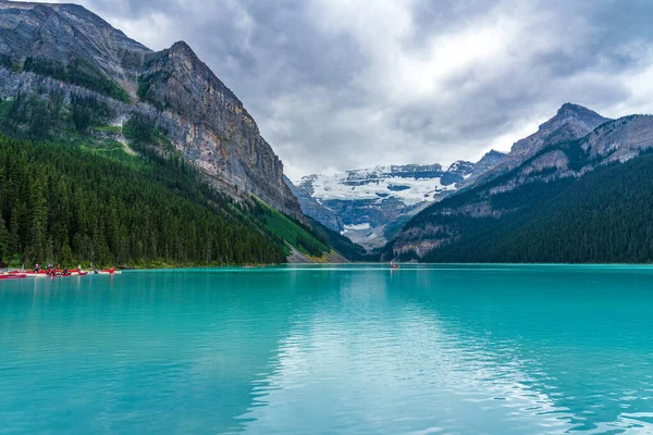 Jízda na kánoi u jezera Louise v letním dni. Turisté mají volný čas vodní aktivity na tyrkysové barvy jezera v Banff National Park, Alberta, Kanada. — Stock fotografie