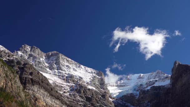 Picos de montaña majestuosos cubiertos de nieve con cielo azul oscuro y nubes que fluyen en el fondo. Valle de los Diez Picos, Monte Babel, Monte Fay, Pico Tonsa. Banff National Park, Canadian Rockies, Alberta, Canadá. — Vídeos de Stock