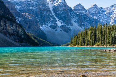 Moraine Gölü. Güneşli yaz sabahında güzel bir manzara. Işıltılı turkuaz mavi su, karla kaplı On Tepe Vadisi. Banff Ulusal Parkı, Kanada Kayalıkları, Alberta, Kanada