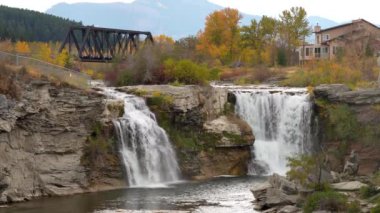 Lundbreck Şelalesi, Crowsnest Nehri 'nin sonbahar yaprakları mevsiminde bir şelalesi. Arka planda demiryolu rayları için demir bir köprü. Alberta, Kanada.