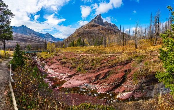 Sonbahar yeşillik mevsiminde Red Rock Kanyonu sabahı. Blakiston Dağı, arkasında beyaz bulutlar olan mavi gökyüzü. Waterton Lakes Ulusal Parkı, Alberta, Kanada. — Stok fotoğraf