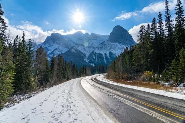 이른 겨울의 화창 한 아침에 세 자매 파크 웨이 (742 번 도로 ) 가 있다. 맑은 푸른 하늘과 뒤에는 로렌스 그라시 산이 눈으로 덮여 있었다. Canmore, AB, Canada. — 스톡 사진