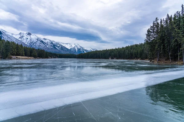 Johnson Gölü 'nün donmuş su yüzeyi kışın. Arka planda karla kaplı dağ. Bu sezonda turistler buz pateni yapıyor. Banff Ulusal Parkı, Kanada Kayalıkları, Alberta, Kanada. — Stok fotoğraf