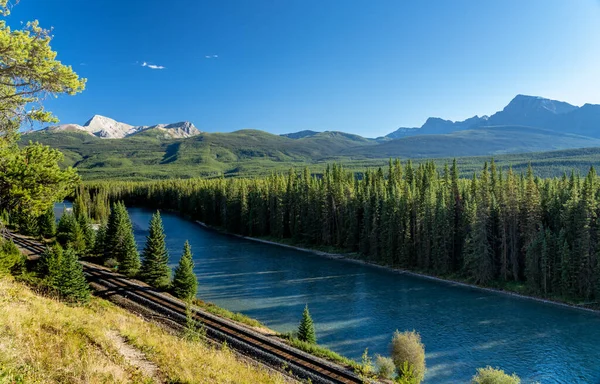 Bow River flows through forest and railway track. Storm Mountain in the background. Castle Cliff Viewpoint, Bow Valley Parkway, Banff National Park, Canadian Rockies, Alberta, Canada.