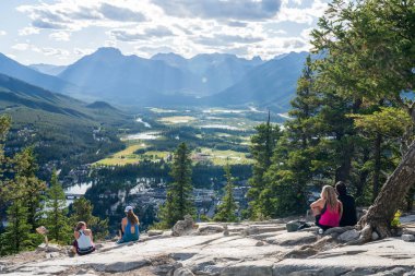 Banff, Alberta, Kanada - 28 AUG 2020: Güneşli yaz gününde Tunnel Dağı Zirvesi 'nden Banff Kasabası' na bakan turistler. Banff Ulusal Parkı, Kanada Kayalıkları.