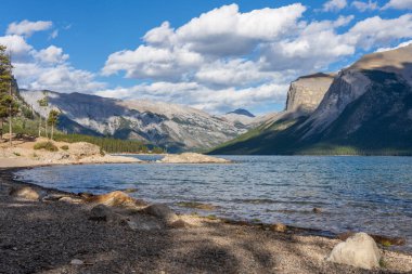Minnewanka Gölü yaz gününde çok güzel bir manzara. Banff Ulusal Parkı 'nda tekne gezisi ve dağ yürüyüşü, Kanada Kayalıkları gibi eğlence etkinliklerinin ünlü turistik cazibesi..