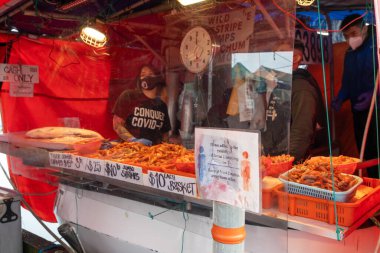Richmond, BC, Kanada - MAR 13 2021: Steveston Limanı Balıkçı İskelesi. Balıkçılar teknede balık satar. Covid-19 salgını sırasında yüz maskesi takan insanlar.