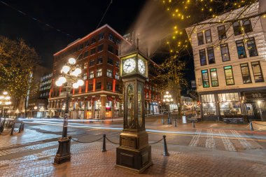 Vancouver, Canada - MAR 16 2021 : Gastown Steam Clock and downtown beautiful street view at night. Cambie and Water Street. clipart