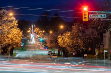 Vancouver, Kanada - MAR 20 2021: Vancouver City kiraz çiçeği mevsiminde. Granville Caddesi ve 16. batı caddesi, bahar gecesi..