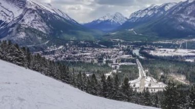 Kar mevsiminde Banff Kasabası. Arka planda kar kaplı Rundle Dağı, sülfür dağı. Norquay Banff Dağı 'nın manzarası. Banff Ulusal Parkı, Alberta, Kanada. 4K Zaman atlamalı yakınlaştır.