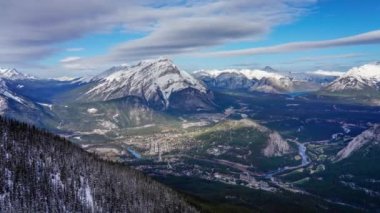 Banff 'ın Bow Valley Kasabası' na bak. Şelale Dağı ve kışın güneşli bir günde Kanada Kayalıkları 'nın etrafı. Banff Ulusal Parkı, Alberta, Kanada. 4K 'da hızlandırılmış yakınlaştırma.