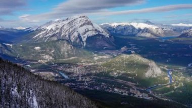 Banff 'ın Bow Valley Kasabası' na bak. Şelale Dağı ve kışın güneşli bir günde Kanada Kayalıkları 'nın etrafı. Banff Ulusal Parkı, Alberta, Kanada. Hızlandırılmış yakınlaştırma 4K.