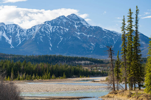 Jasper, Alberta, Canada - May 1 2021 : Canadian National Railway freight train. Canadian Rockies, Jasper National Park.