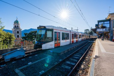 Lugano, Ticino Kantonu, İsviçre - 3 Kasım 2025: Ferrovie Luganesi FLP tren istasyonu ve turuncu kapı treni.