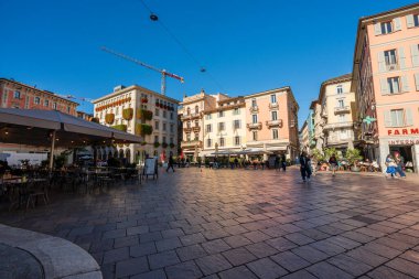 Lugano, Ticino Kantonu, İsviçre - 3 Kasım 2025: Pastel binaları ve kafeleri olan Piazza della Riforma ana meydanı.