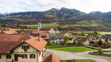 Albeuve köyü Eglise Saint-Pierre-aux-Liens beyaz kilisesi ve Intyamon vadisinde sonbahar manzarası. Haut-Intyamon, Fribourg, İsviçre.