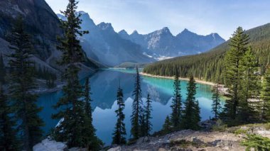 Banff Ulusal Parkı Moraine Gölü 'nün gün doğumunda gölgeler canlı turkuaz su açığa çıkarıyor. Alberta, Kanada