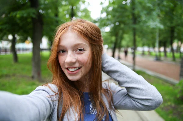Dziewczyna idzie w parku i sprawia, że selfie. — Zdjęcie stockowe