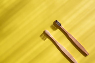 Kopya alanı olan parlak sarı arkaplanlı eko bambu diş fırçaları. Organik hijyen ürünleri..
