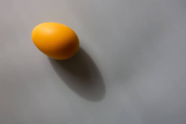 Fotokopi alanı olan gri bir arka planda bir sarı yumurta. Yılın Renkleri 2021.