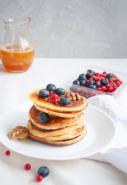 Beyaz tabakta yaban mersini ve ahududu ile nefis krepler..