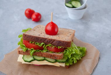 Taze marul yapraklı, domatesli, salatalıklı ve peynirli lezzetli sandviç..