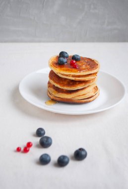 Beyaz tabakta yaban mersini ve ahududu ile nefis krepler..