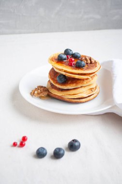 Beyaz tabakta yaban mersini ve ahududu ile nefis krepler..