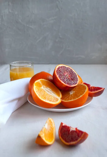 Fresh delicious cut variety of oranges on a hite plate. — Stock Photo, Image