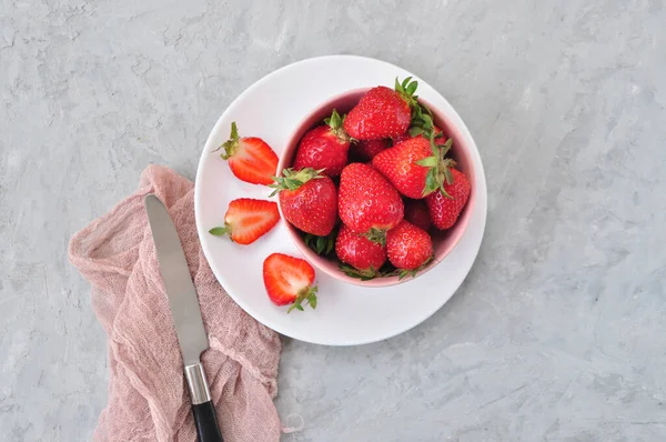 Fresas frescas maduras en un bol sobre fondo gris. —  Fotos de Stock