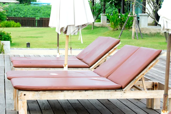 Cama de madeira dispostas ao lado da piscina — Fotografia de Stock
