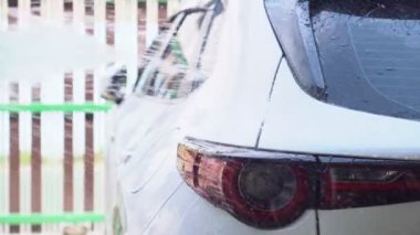 Hortumdan çıkan temiz suyla arabayı yıka. Su tasarrufu kavramı.