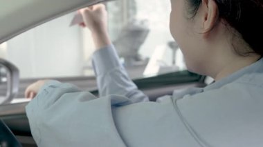 Asyalı genç bir kadın yiyecek ve içecekler için sipariş verir ya da ödeme yapar ve kredi kartıyla ya arabayla ya da arabayla geçer. Temassız ödeme, Temassız Teslimat.