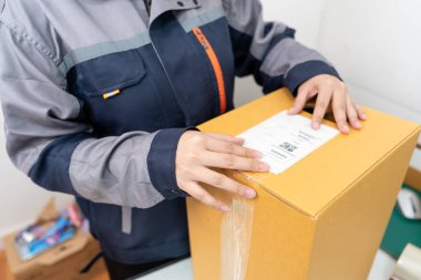 Posta çalışanları paket kutularını barkod etiketleri ekleyerek hallediyorlar..