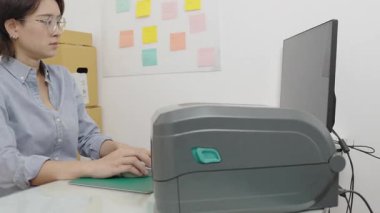 Asyalı kadın inşaat işçisi ofise not yazıyor ya da yapıştırıyor.