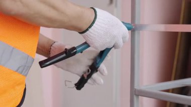 Adamın eli perçin tabanca ya da perçin pense kullanarak alüminyumu çeliğe takar..