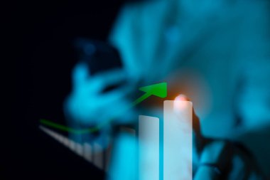 İş kadını akıllı telefonu borsaya bakmak veya grafikleri çizmek için kullanır ve kar, artış, analist veya yatırımcı ticareti için takas eder, maliye grafikleri, çift pozlama veya üst üste bindirme.