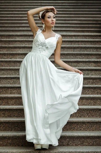Brunette vrouw in witte bruiloft jurk — Stockfoto