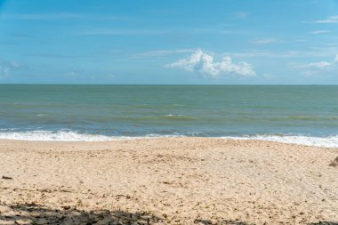 Yazın mavi deniz manzarası turkuaz dalgalı, beyaz kumlu plaj ve Malezya 'nın Desaru kıyısında mavi bulutlu gökyüzü