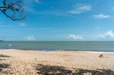 Yazın mavi deniz manzarası turkuaz dalgalı, beyaz kumlu plaj ve Malezya 'nın Desaru kıyısında mavi bulutlu gökyüzü