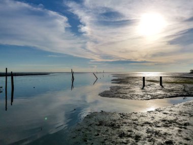 Manzaralı deniz manzarası, gün batımı ve dallar ve mavi gökyüzü çamurlu bataklıklı deniz suyu, Parit Jawa, Malezya.