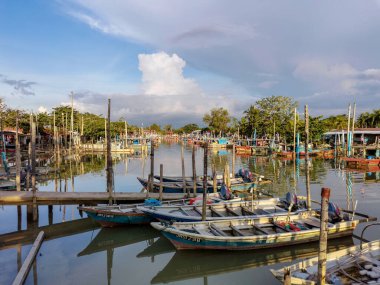 Eski iskele balıkçı köyüne park etmiş renkli ahşap balıkçı tekneleri, balıkçı tekneleri, mangrov ormanları ve su üzerinde mavi gökyüzü, Parit Jawa, Malezya