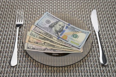 Dolar faturaları bir tabak çatal ve bıçak
