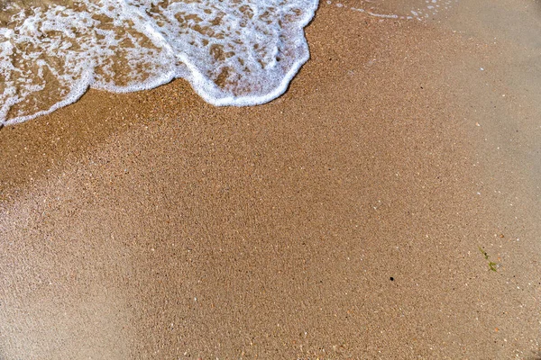 Waves with sea foam on a sandy beach — Stock Photo, Image
