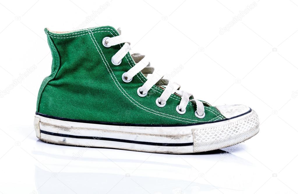 Old green sneakers on white background