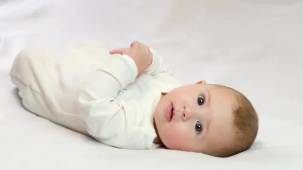 Baby on a white background lies smiling. selective focus — Stock Video